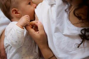 Close-up of a loving caring mother breastfeeding her baby boy. View from above photo