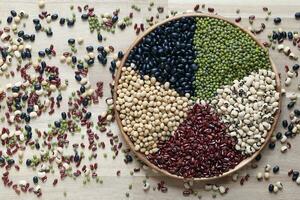 Top view of five colored beans in a bowl on wooder background, Healthy eating concept photo