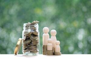 modelo familia y apilar de monedas dinero en el vaso botella en natural verde fondo, guardar dinero para preparar en futuro y familia Finanzas concepto foto