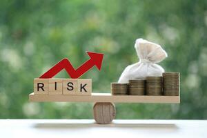 Risk word with red arrow graph and money bag on natural green background, Business investment and Risk management concept.Financial risk assessment photo