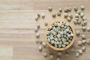 Top view of green peas in a bowl on wooder background, Healthy eating concept photo