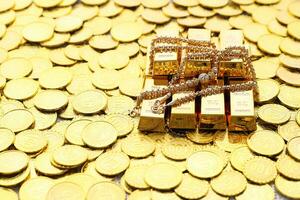 Gold necklaces and have gold bars with stack of coins money on yellow background, Business investment and Saving money for prepare in future concept photo