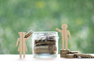 Love couple putting a coin into the glass bottle on green background, Finance, Saving for lover or family and save money for prepare in future concept photo