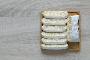 Raw tempeh, Top view of tempeh slices in a bowl on wooder background, Healthy eating concept photo