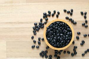 Top view of black beans in a bowl on wooder background, Healthy eating concept photo