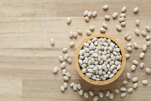 Top view of white beans in a bowl on wooder background, Healthy eating concept photo