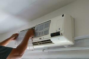 técnico Servicio limpieza y Lavado mantenimiento o reparando aire acondicionador en el pared foto