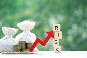 Risk word with red arrow graph and money bag on natural green background, Business investment and Risk management concept.Financial risk assessment photo