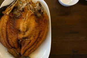 Fried Sea bass with fish sauce in Thai restaurant photo