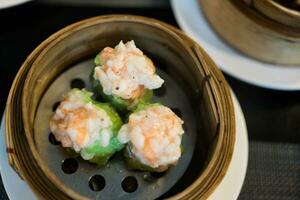 Hot steamed shrimp dumplings look delicious, dumplings recipe wrapped by green wonton wrapper photo