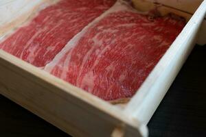 raro rebanado carne de vaca con un jaspeado textura servido en un madera caja. prima calidad carne de vaca foto