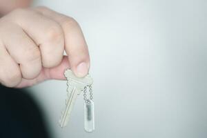 Man hand holding the key to a new home, dream of homeownership. photo