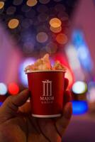 Bangkok, Thailand - December 27, 2023 A mini cup of popcorn for tester new popcorn taste from Major Cineplex Thailandd photo