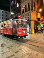 16 of April 2023 - Istanbul, Turkey - City life, the people and famous red tram on Istiklal pedestrian street photo