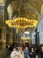 17 of April 2023 - Istanbul, Turkey - Interior decoration of Hagia Sofia, beautiful chandeliers, frescoes and tourists photo