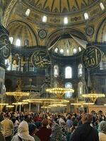 17 of April 2023 - Istanbul, Turkey - Interior decoration of Hagia Sofia, beautiful chandeliers, frescoes and tourists photo