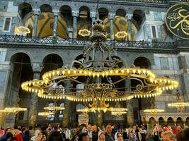 17 of April 2023 - Istanbul, Turkey - Interior decoration of Hagia Sofia, beautiful chandeliers, frescoes and tourists photo