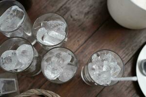 Many glass of ice in clear glass cup in table dinner photo