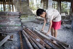 Children forced to work hard at construction site, child labor concept, poor children victims of human trafficking process, poverty, child abuse. photo