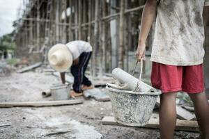 Concept of child labor, poor children being victims of construction labor, human trafficking, child abuse. photo