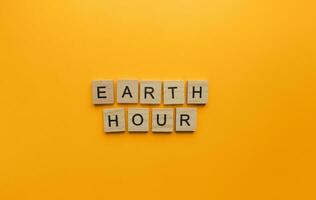 March 25, Earth Hour, a minimalistic banner with an inscription in wooden letters photo
