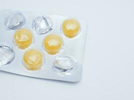 Yellow pills in blister pack isolated on white background with copy space. photo