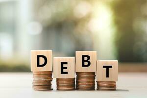 Debt, Debt burden, Financial Loan, Loan payment, Credit Limit, Bankruptcy, Poverty, Rise of interest rates and prices, mortgage, money and financial problem concept. DEBT word on stack of money. photo