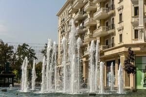 Water fountain with splashes of water for relaxation and coolness of the city and parks photo