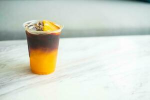 Iced americano mixed orange juice in plastic cup. photo