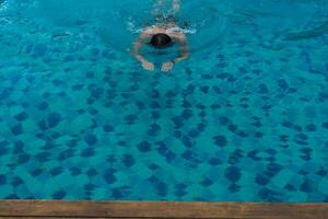 hombre nadar en el piscina a el hotel foto