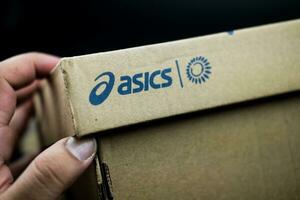 Bangkok, Thailand - January 7, 2024 Man hand open shoe box with Asics logo. Asics logo. photo