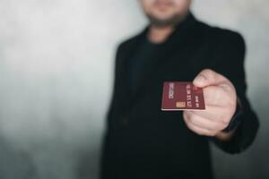 Businessman in a black suit standing holding a credit card to pay for online shopping. photo