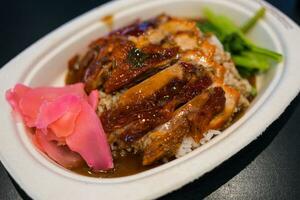 Roasted duck with gravy and rice on plate photo