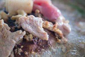 Pork or meat on the hot pan. or Traditional Thai style BBQ photo