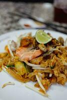 Pat Thai, rice noodles fried with tofu, vegetable, egg and seafood. photo