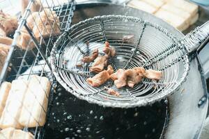 haciendo frito entrañas de cerdo en caliente aceite, phuket tradicional comida es llamado loba. foto