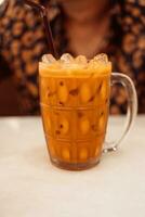 un vaso frio de tailandés Leche té en Clásico vaso. foto