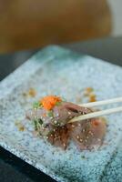 Use chopsticks eating best grade Japanese wagyu beef sushi. photo