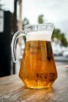 Fresh beer fills a crystal of jar glass with natural light photo