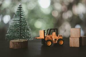 Forklift toy model ready to move Christmas tree. Christmas concept photo