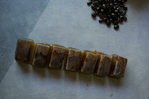 Ice cubes with coffee beans. Frozen black coffee photo
