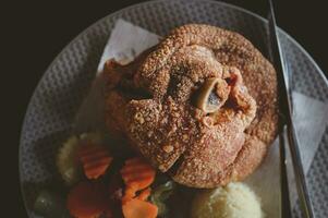 Deep fried pork knuckle eating with beer in restaurant photo