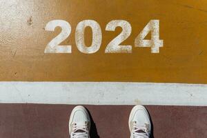 The beginning of 2024 is written on a colorful road. Conceptual photo of the coming New Year 2024. New year concept, motivation, business promotion, step forward, moving forward, hope