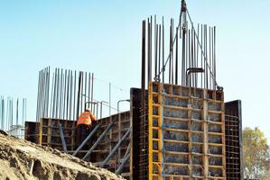 High rise building under construction. Installation of glass facade panels on a reinforced concrete structure. photo