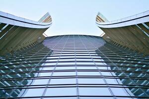 Glass building with transparent facade of the building and blue sky. Structural glass wall reflecting blue sky. Abstract modern architecture fragment. Contemporary architectural background. photo