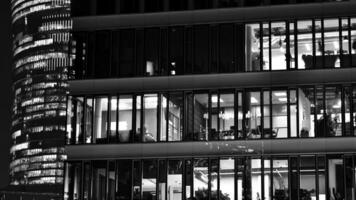 Pattern of office buildings windows illuminated at night. Glass architecture ,corporate building at night - business concept. Black and white. photo