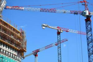 High rise building under construction. Installation of glass facade panels on a reinforced concrete structure. photo