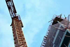 High rise building under construction. Installation of glass facade panels on a reinforced concrete structure. photo