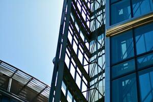 Glass building with transparent facade of the building and blue sky. Structural glass wall reflecting blue sky. Abstract modern architecture fragment. Contemporary architectural background. photo