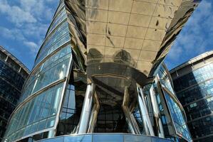 Glass building with transparent facade of the building and blue sky. Structural glass wall reflecting blue sky. Abstract modern architecture fragment. Contemporary architectural background. photo